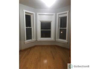An image of an empty bedroom with windows